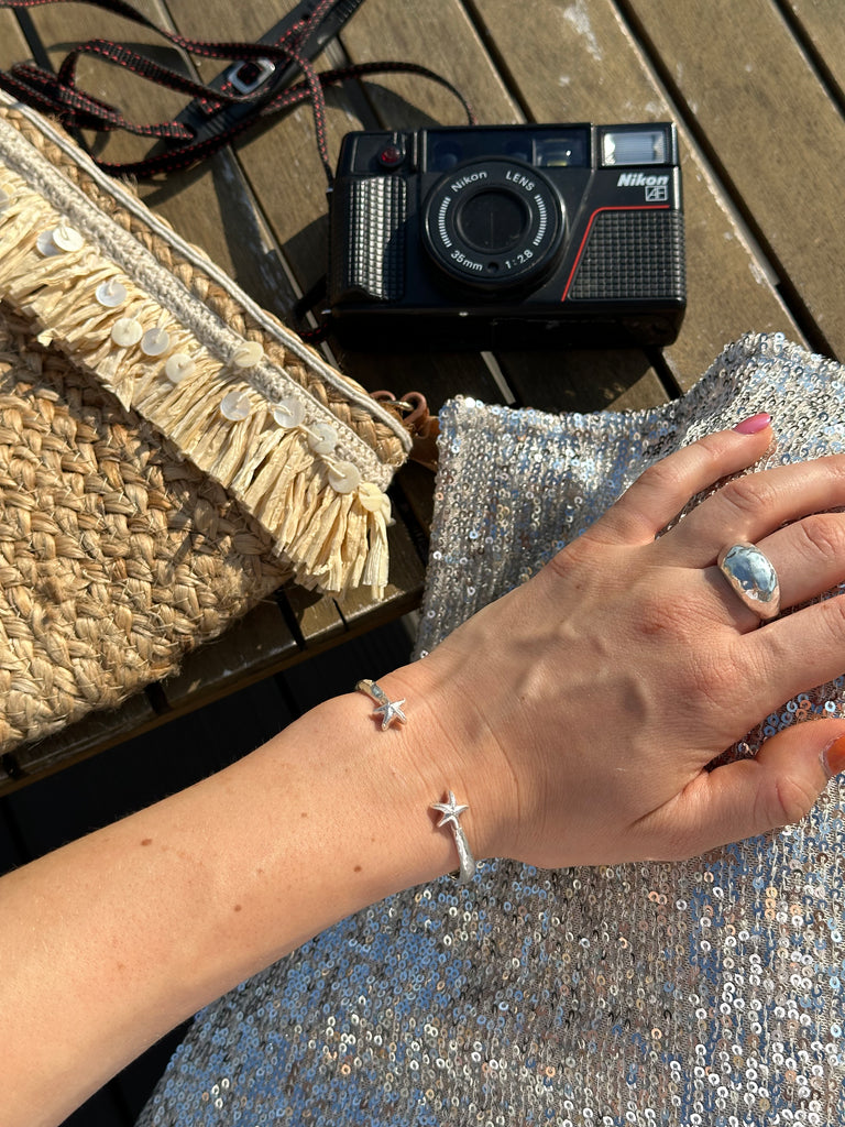 Elegant and durable sterling silver starfish bangle worn by the sea, Alula Collections Jewellery.