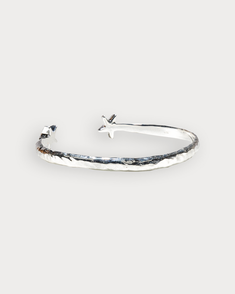 Close-up of handmade sterling silver bangle with starfish detailing side view, made by Alula Collections.